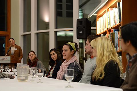 A group of people sitting together with a presenter speaking in the background