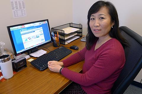 A portrait of a woman sitting with her computer on