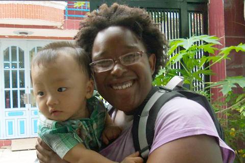 An Arcadia student smiles while holding a baby.