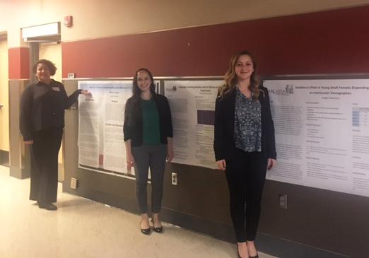 Students standing in front of their research projects.