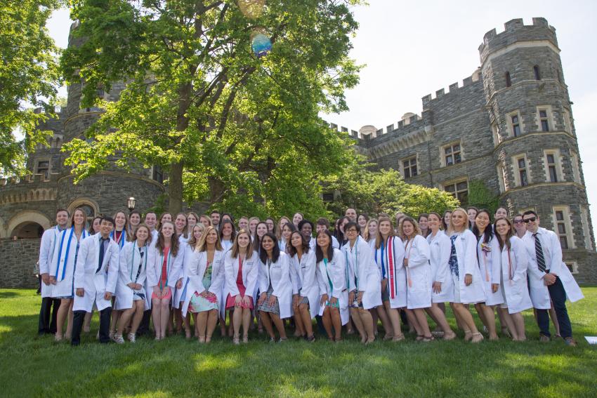 A group photo of white coat ceremony students outside of the castle