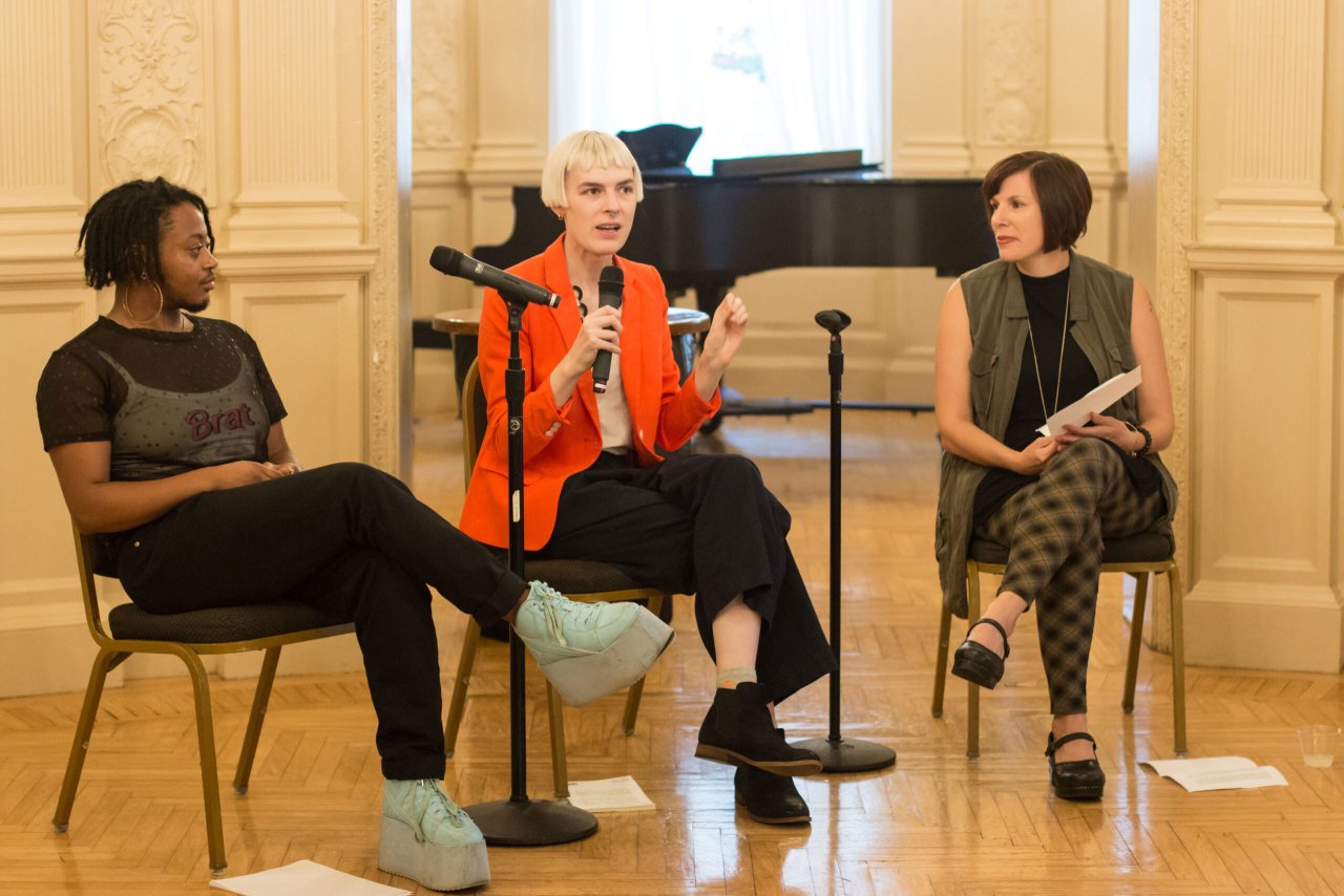 Three panelists speak at an event in the Rose Room.