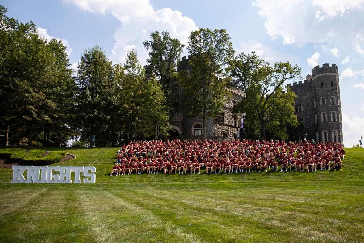 Large group of Arcadia students gathered outdoors on lawn in Knights clothing