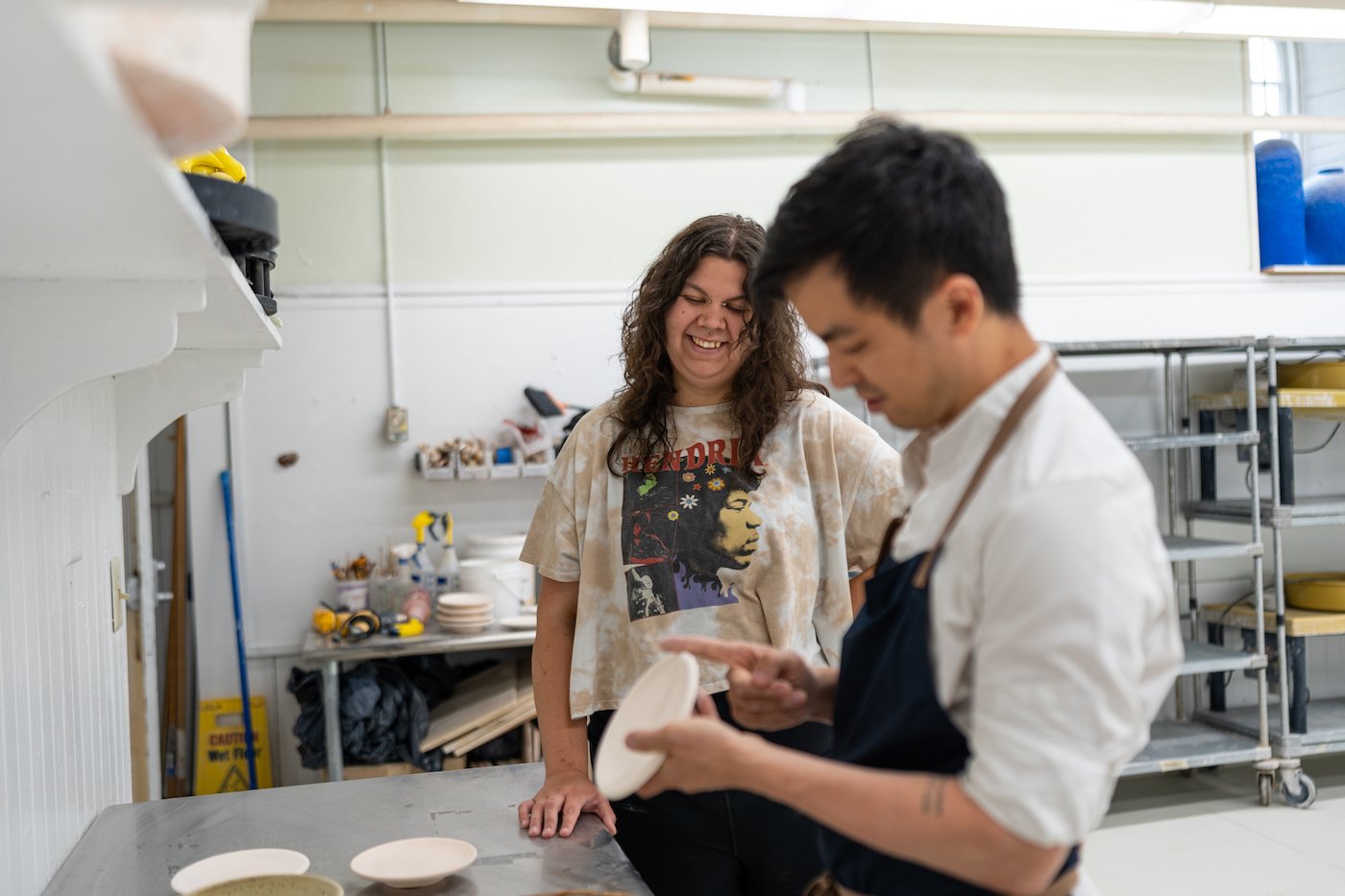 Angelina Brewer ’23 smiles as Chef Hoon Rhee examines her plateware