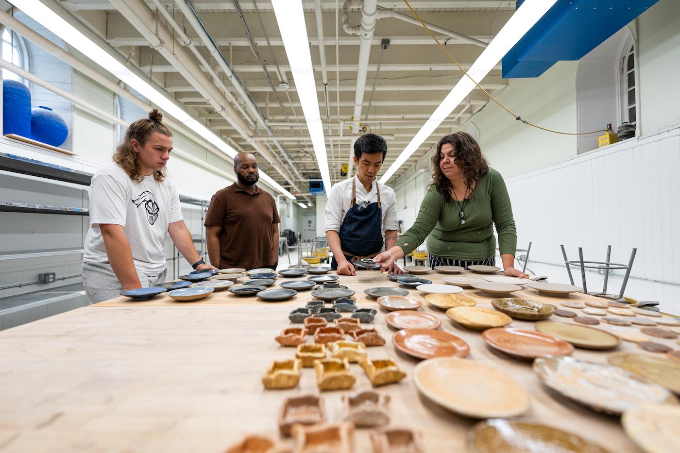 From left to right, Michael Dirienzo ’23, Daniel Mack ’18, ’23M, Chef Hoon Rhee, and Angelina Brewer ’23 examine their plateware