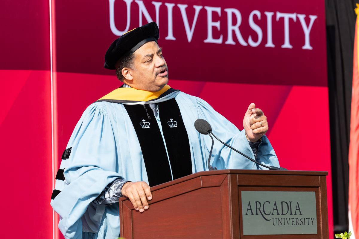 Neil deGrasse Tyson speaking on stage at the graduate commencement ceremony 