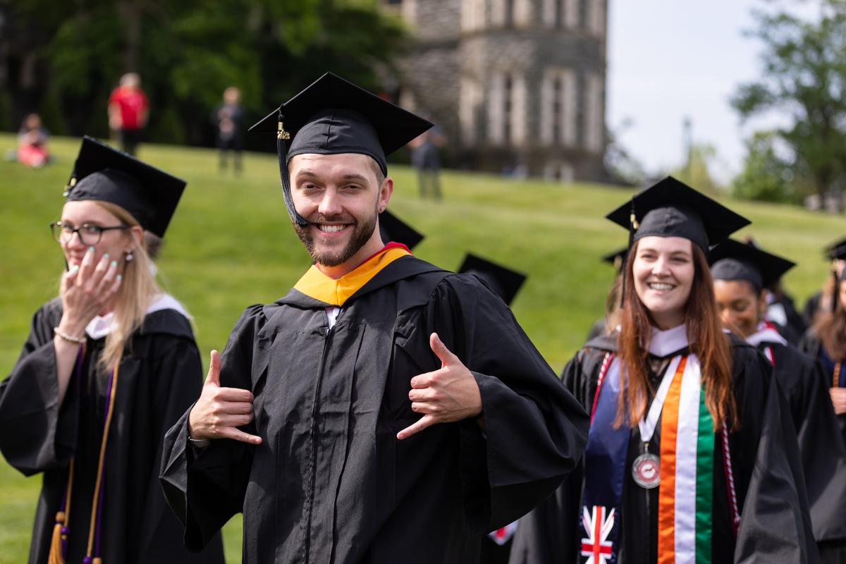 A student smiling during the graduation ceremony on Haber Green 
