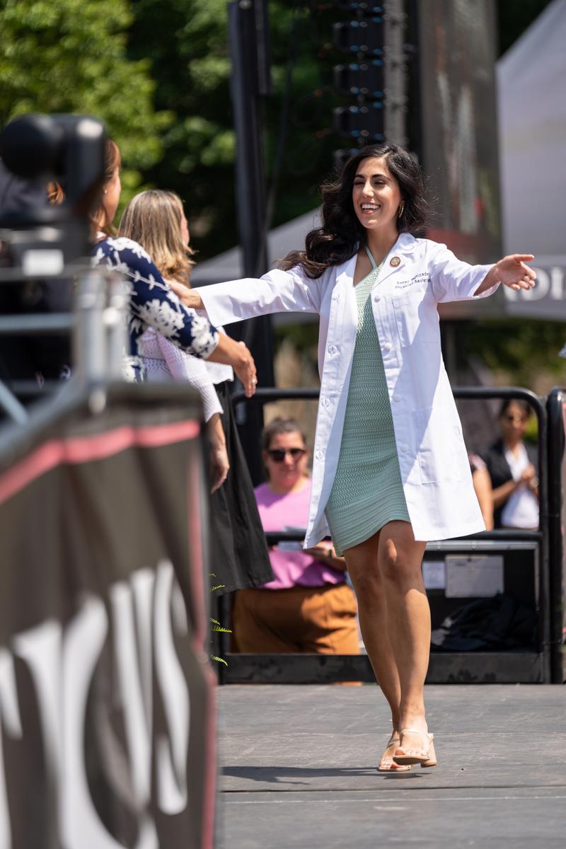 A graduate receives their white coat during the White Coat ceremony