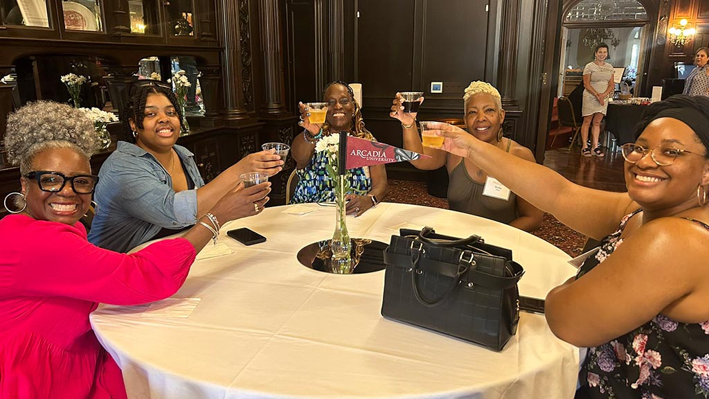 A table of graduates say cheers in the castle.