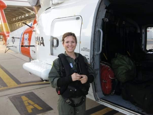 Megan Godsey in military gear next to a helicopter 