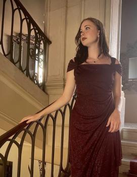 Haylie Jarnutowski in elegant dress on staircase