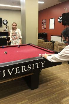 Two students playing pool in the Arcadia Game Room