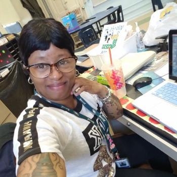 Arcadia University alumna Lattonia Robichaw taking a selfie seated at a desk