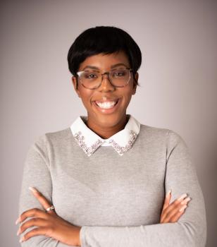 Maya Johnson smiling for portrait with arms crossed