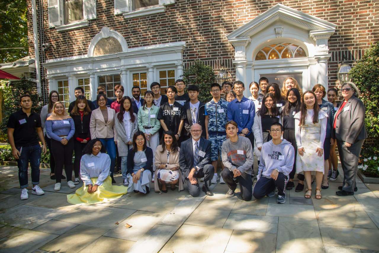 A large group of International students and faculty members outside President's house.