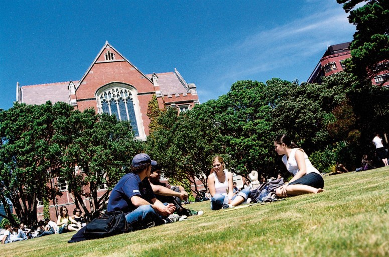 Students sit in grass on Kelburn Campus lawn