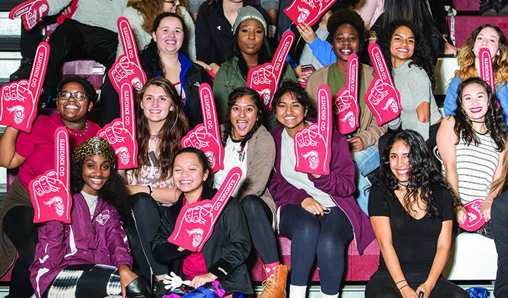 Arcadia grads and students show their spirit with red team hands.