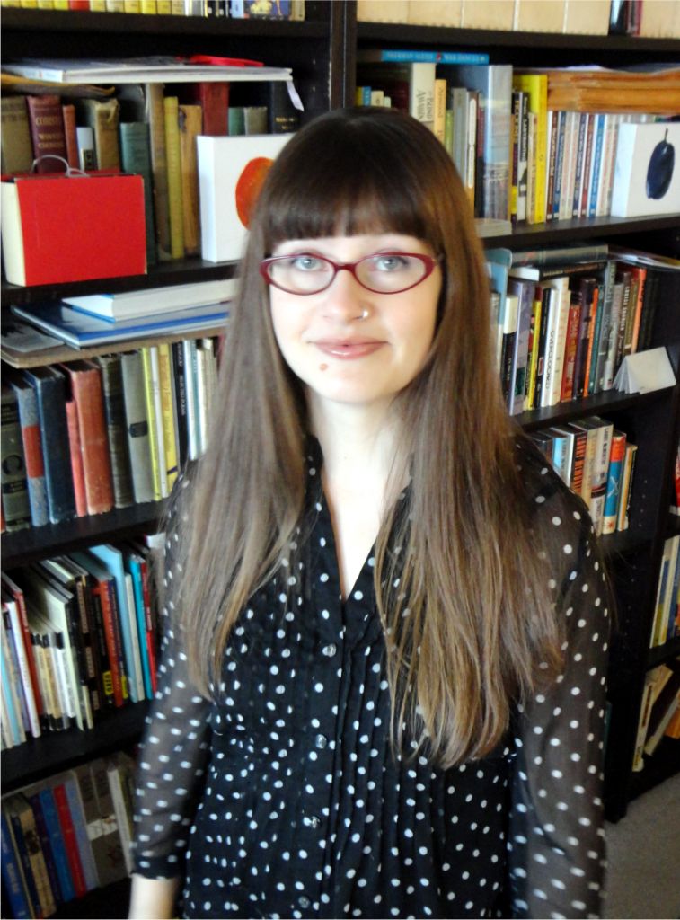 A portrait of a woman with red glasses and a polka dotted blouse