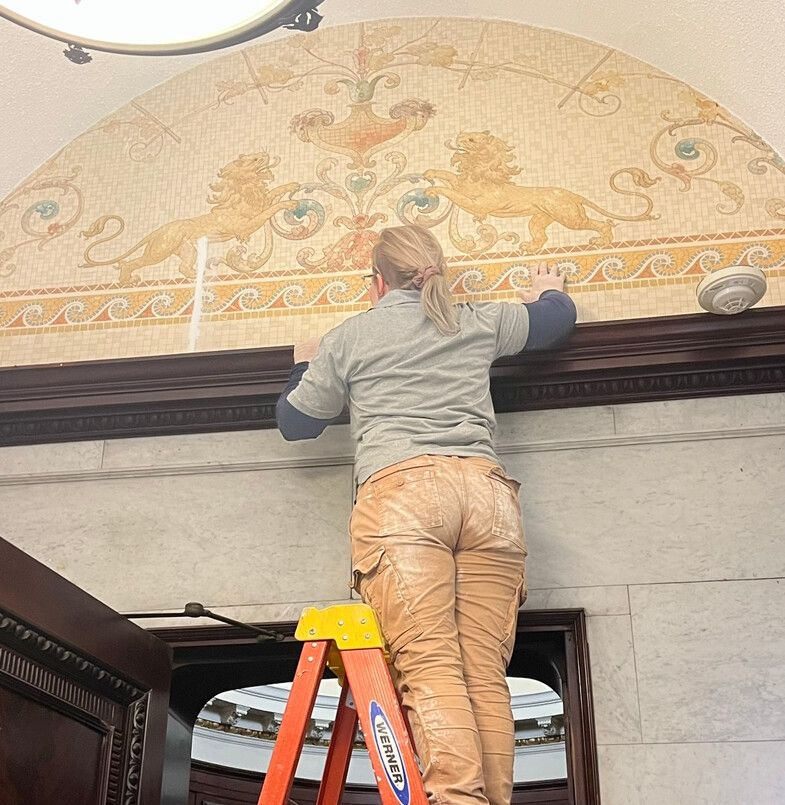 A mural uncovered in a drop ceiling inside a women's restroom in the Castle is restored