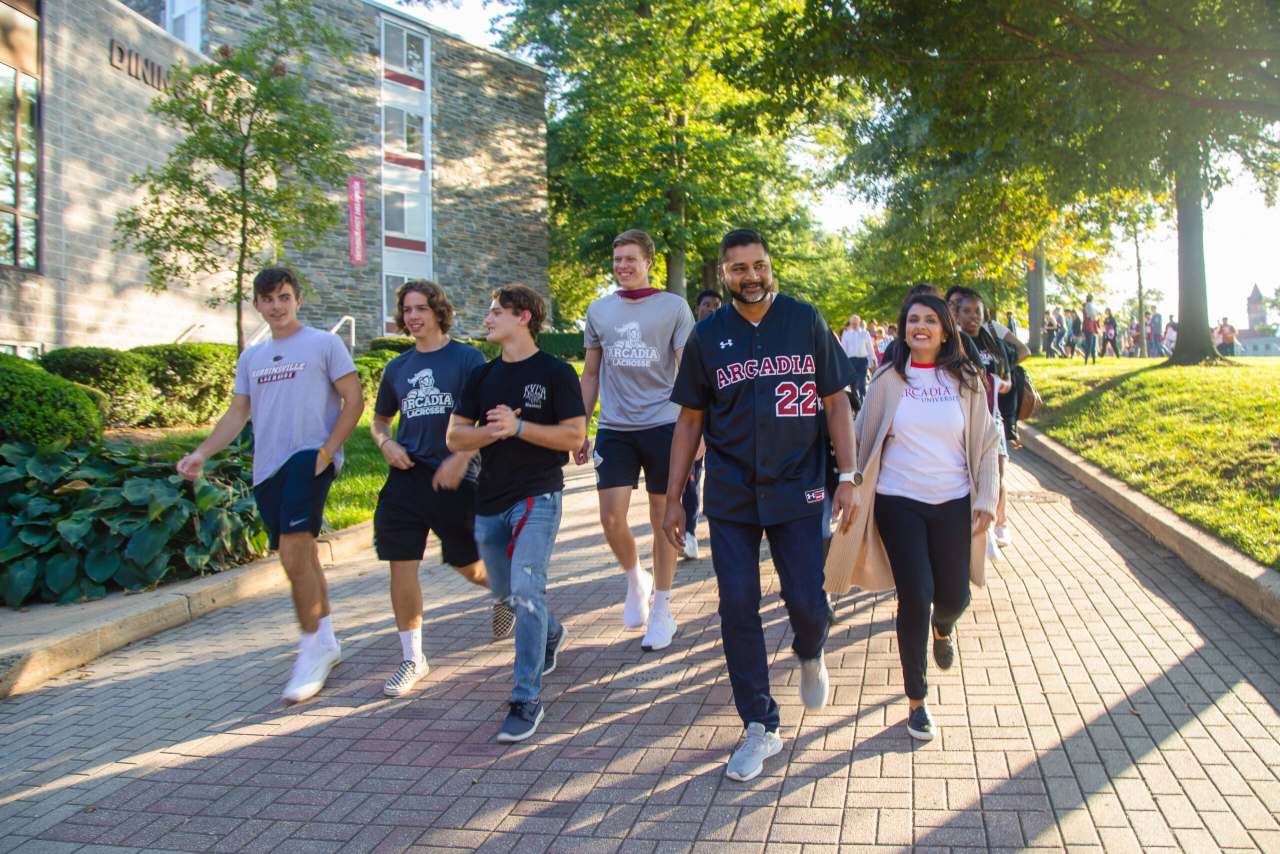 President Nair leading students down the Walk of Pride.