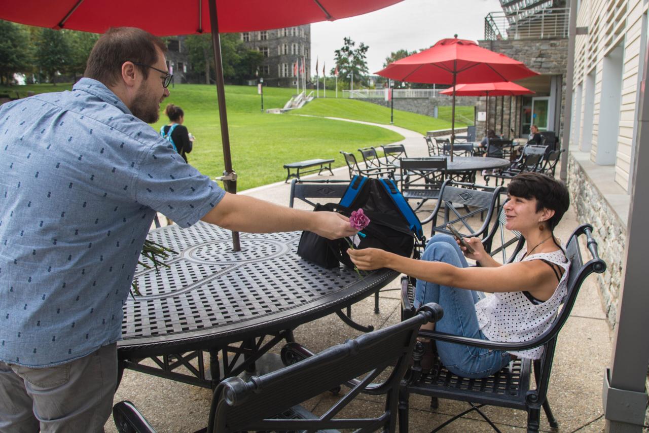 A person handing a flower to another person.