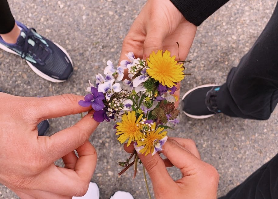 Students hold wildflowers
