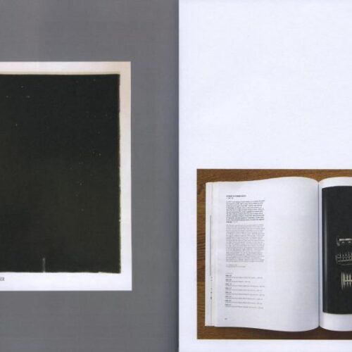 A black screen with a white border and a photo of an open book with a black sheet with symbols on it