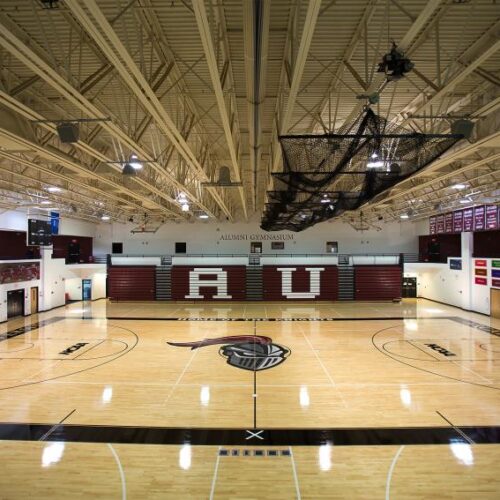 Arcadia University gymnasium, empty and with the seats fully stacked so you can read "A U" on that wall