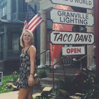 Sarah Mason out of Taco Dan's building posing