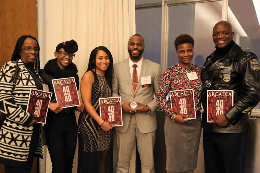 Six people stand close together and smile, holding copies of Arcadia Magazine with the words "40 Under 40" on the cover