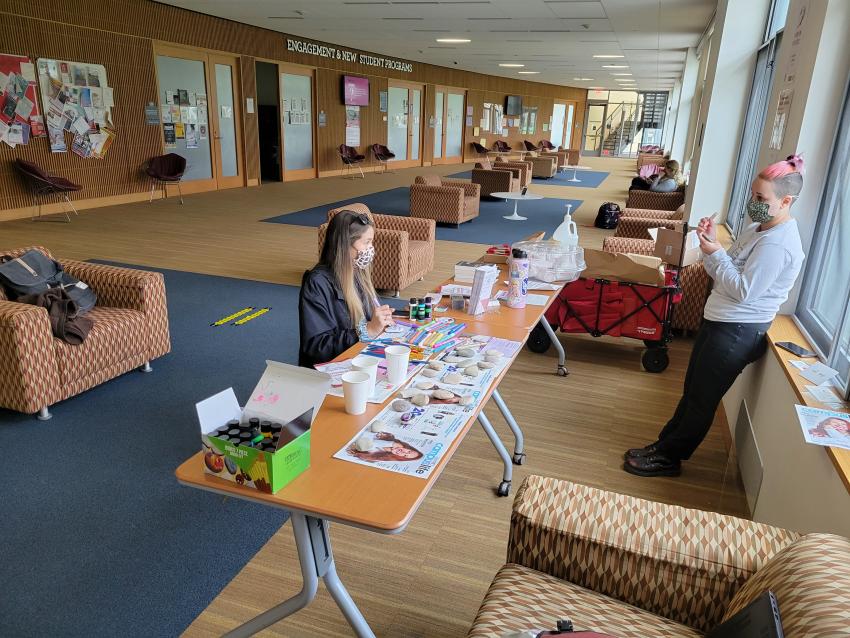 Masked students sit at a table at a wellness fair