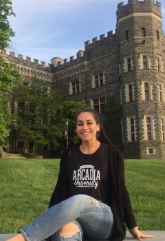 female student posing with castle in background