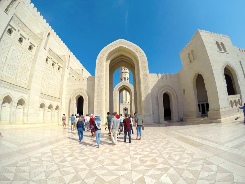 Photo of students studying abroad walking through white marble and stone buildings.