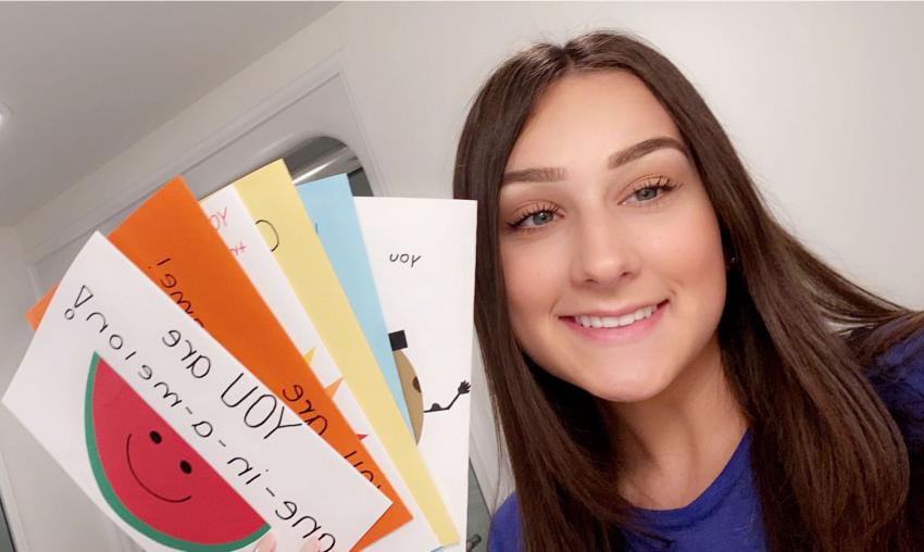 A student holding illustrative flashcards