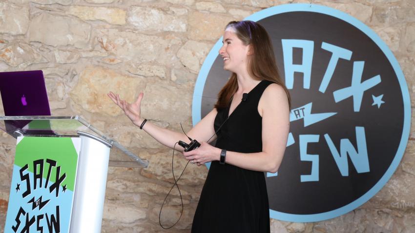 Dr. Moore stands at a podium speaking.