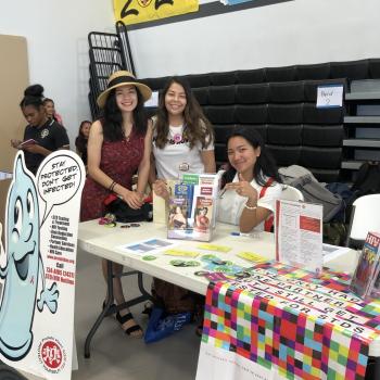 Arcadia student shares about STD prevention at an information table in Guam.