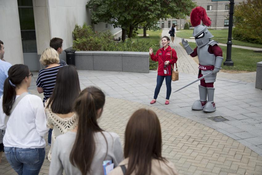 Archie the Knight waving to prospective students on a tour