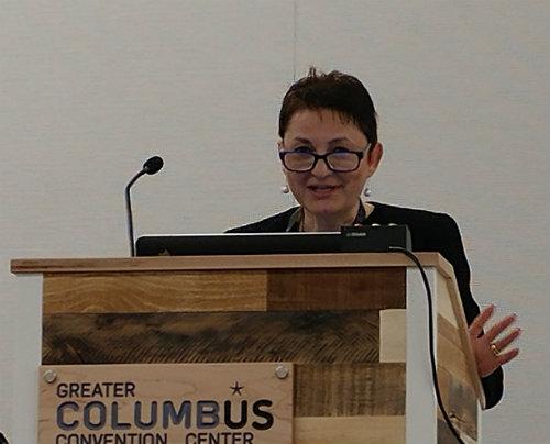 Dr. Sacca stands at a podium.
