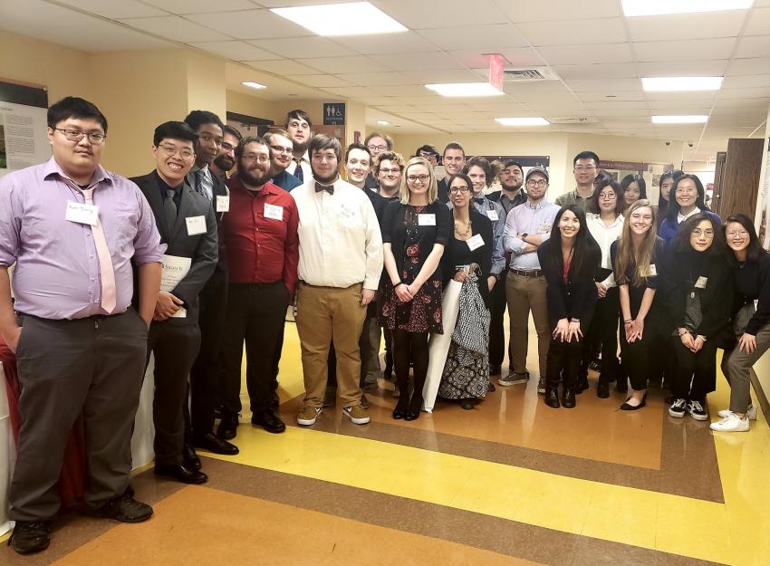 A group photo of students and professors at a Research Symposium