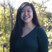 A portrait of Ariel Wong, smiling and standing outdoors on a sunny day