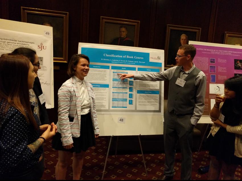 male and female students presenting poster to a group