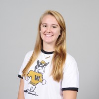 A headshot of a blonde student wearing a white t-shirt