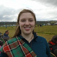 Headshot of Aimee P. wearing a polo shirt with a plaid tunic.