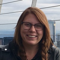 Photo of student at the top of a tower smiling.