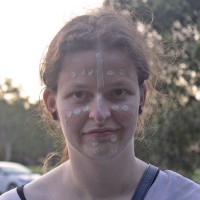 A portrait of a woman with dots and lines painted on her face