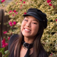 A portrait of Danica Tamura standing in front of a bush