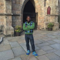 Mark Mlella standing in front of a stone archway.