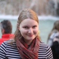 A portrait of a woman wearing a scarf and a black and white striped shirt