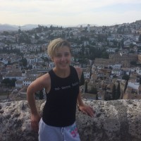 Maddie Ritter posed by view of a valley with village homes.