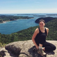 Mary Schrott sitting on a rock with a view of the water below.